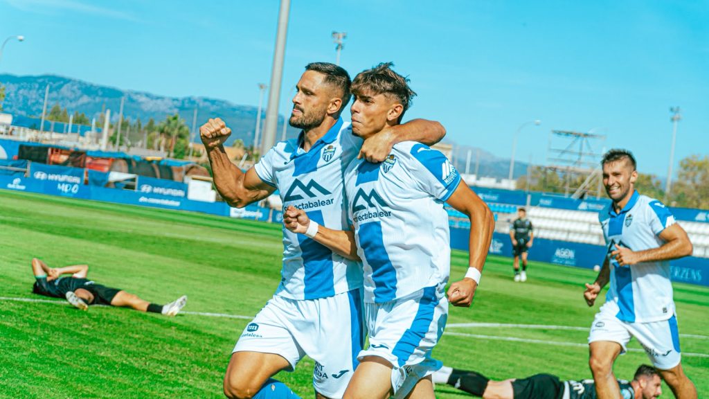 Vista d'un camp de futbol amb gespa verda i una pilota a prop de la línia de banda