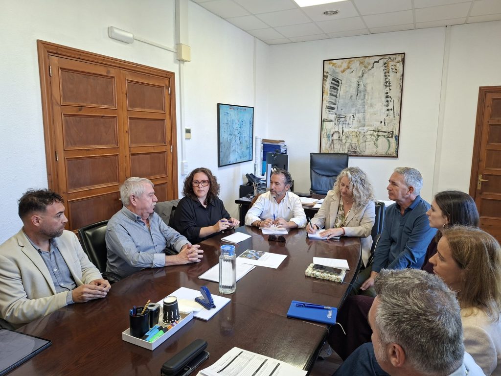 Carrer urbà d'un poble de Mallorca amb asfalt desgastat i bassals després de la pluja