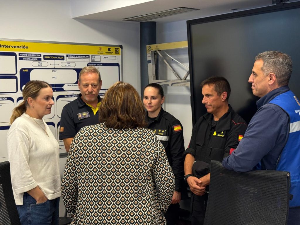 Carrer inundat d'un poble mallorquí després d'un temporal de pluja, amb bassals d'aigua i branques caigudes, cel encara carregat i llum grisa de capvespre