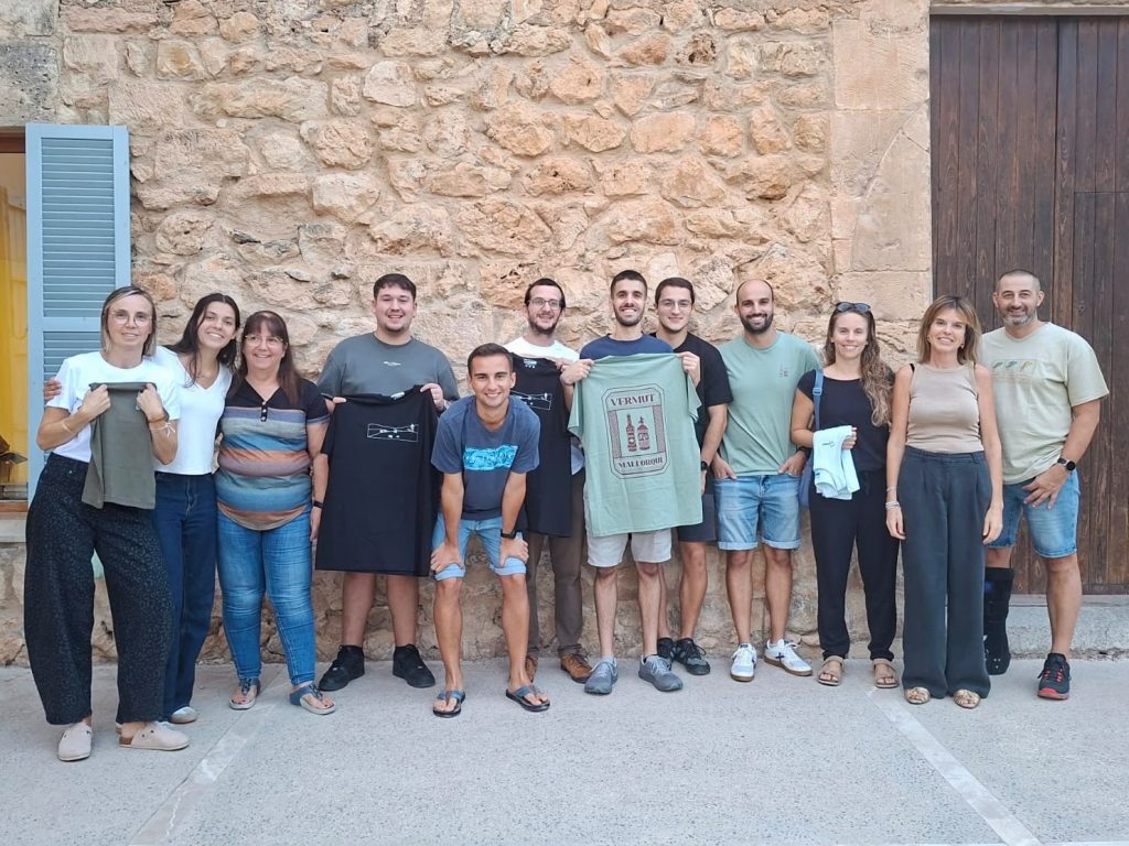 Carrer de Manacor engalanat durant una festa popular, amb gent vestida de manera tradicional i colors vius, llum de dia
