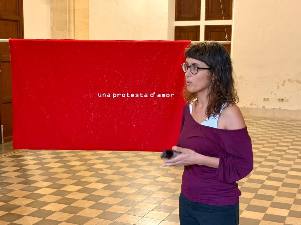 Exposició d'art contemporani amb obres teixides i brodades en una sala d'exposicions